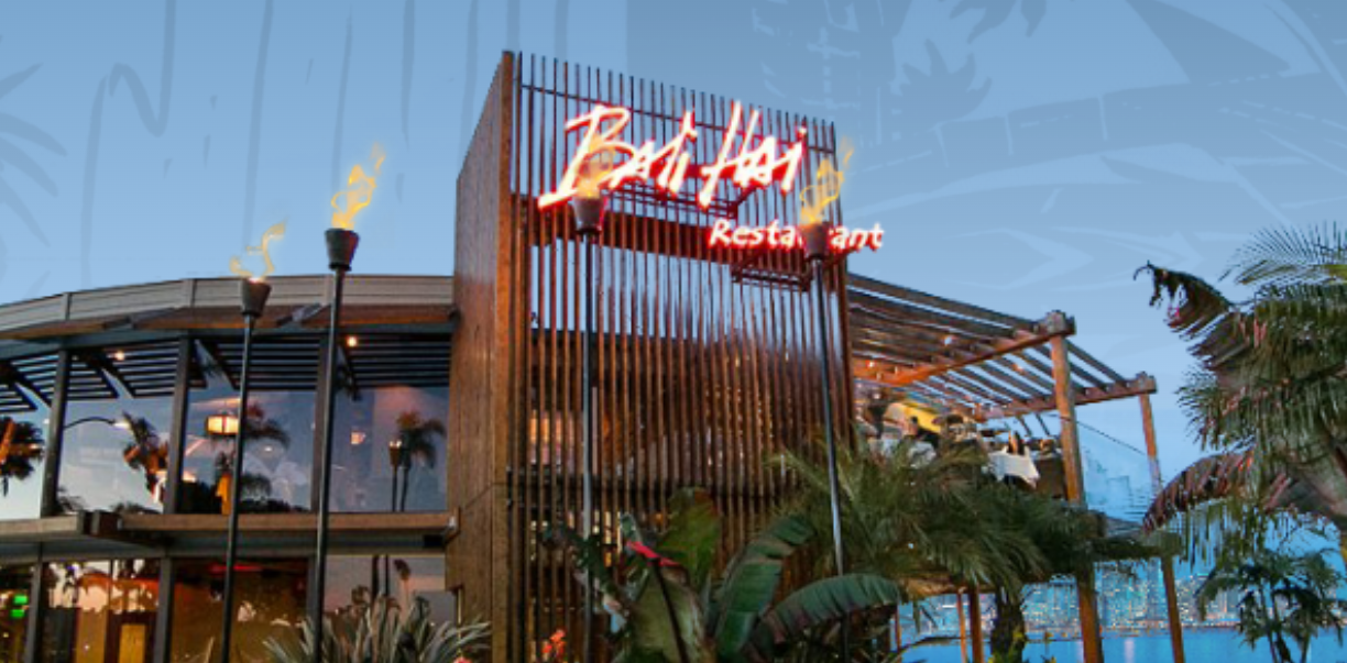 Tropical-themed restaurant with neon sign and palm trees.