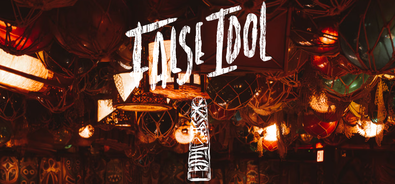 Dimly lit bar with warm colored lights and "False Idol" sign.