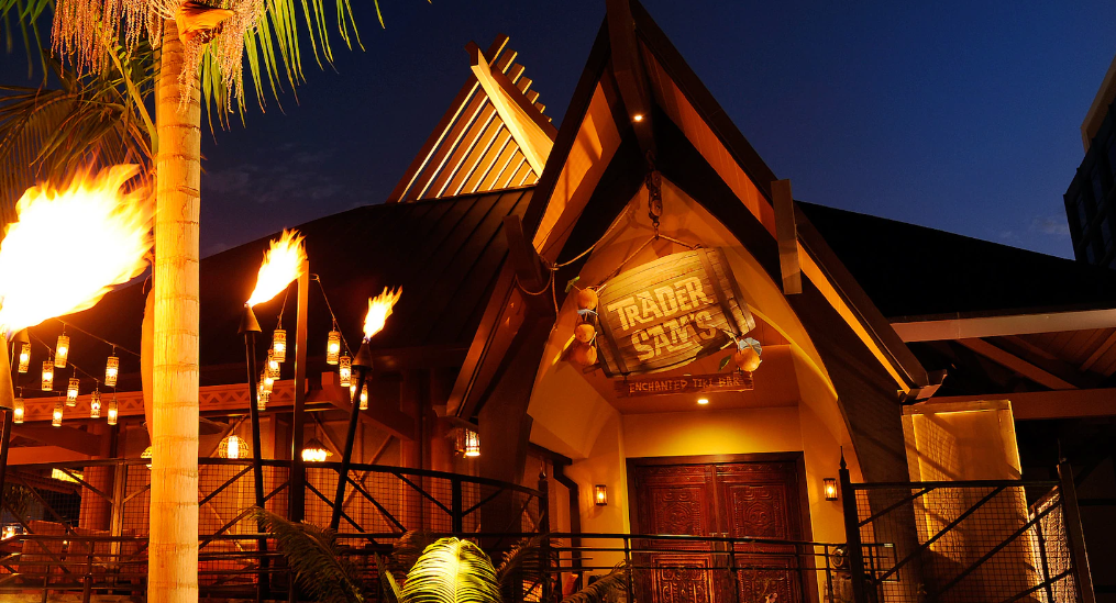 Tropical-style restaurant entrance at night, lit by torches.