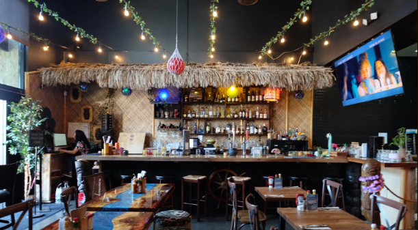 Tropical-themed bar with hanging lights and tiki decor.