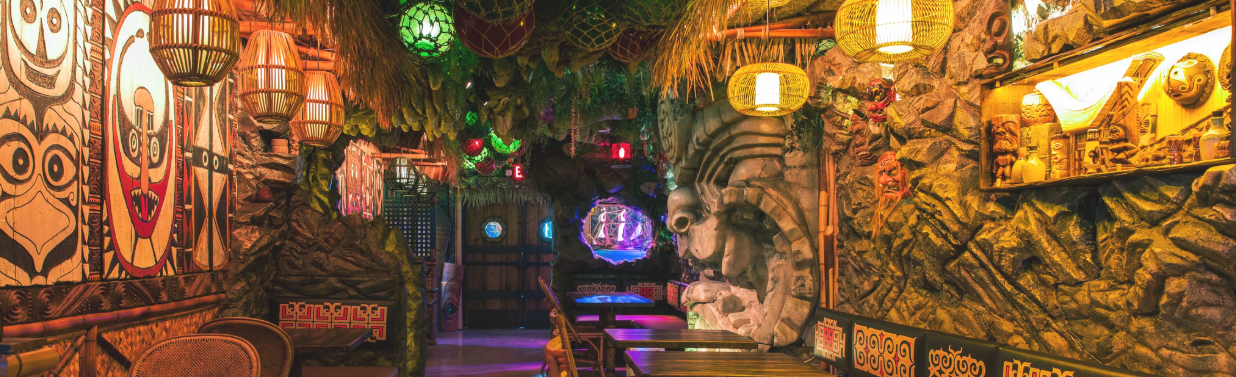 Colorful, decorated bar interior with glowing lanterns and wall art.
