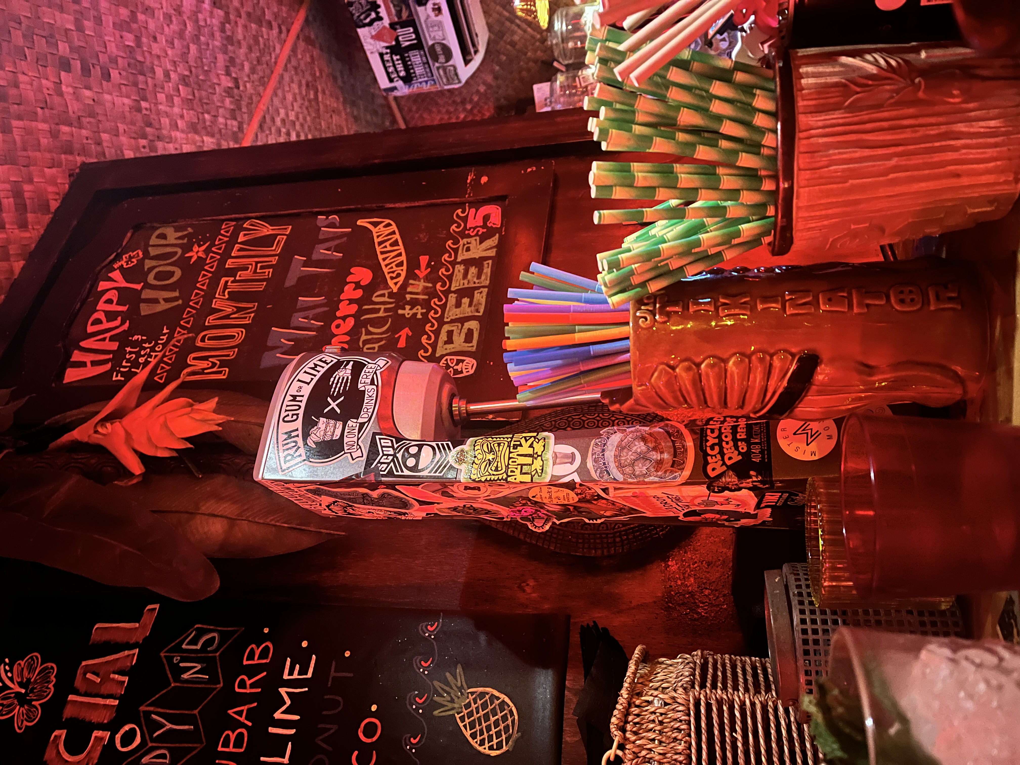 Bar counter with colorful straws and festive decor.
