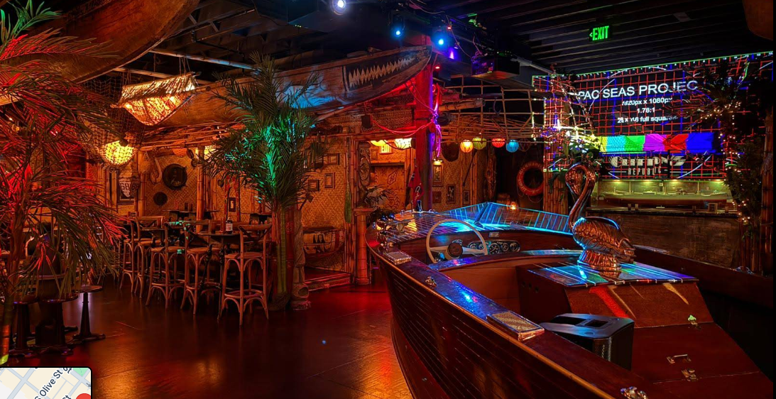 Tropical-themed bar with colorful lights and palm decor.