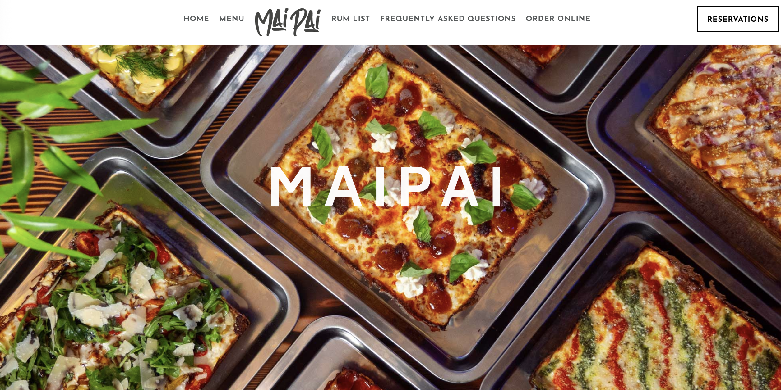 Assorted square pizzas with various toppings in trays.