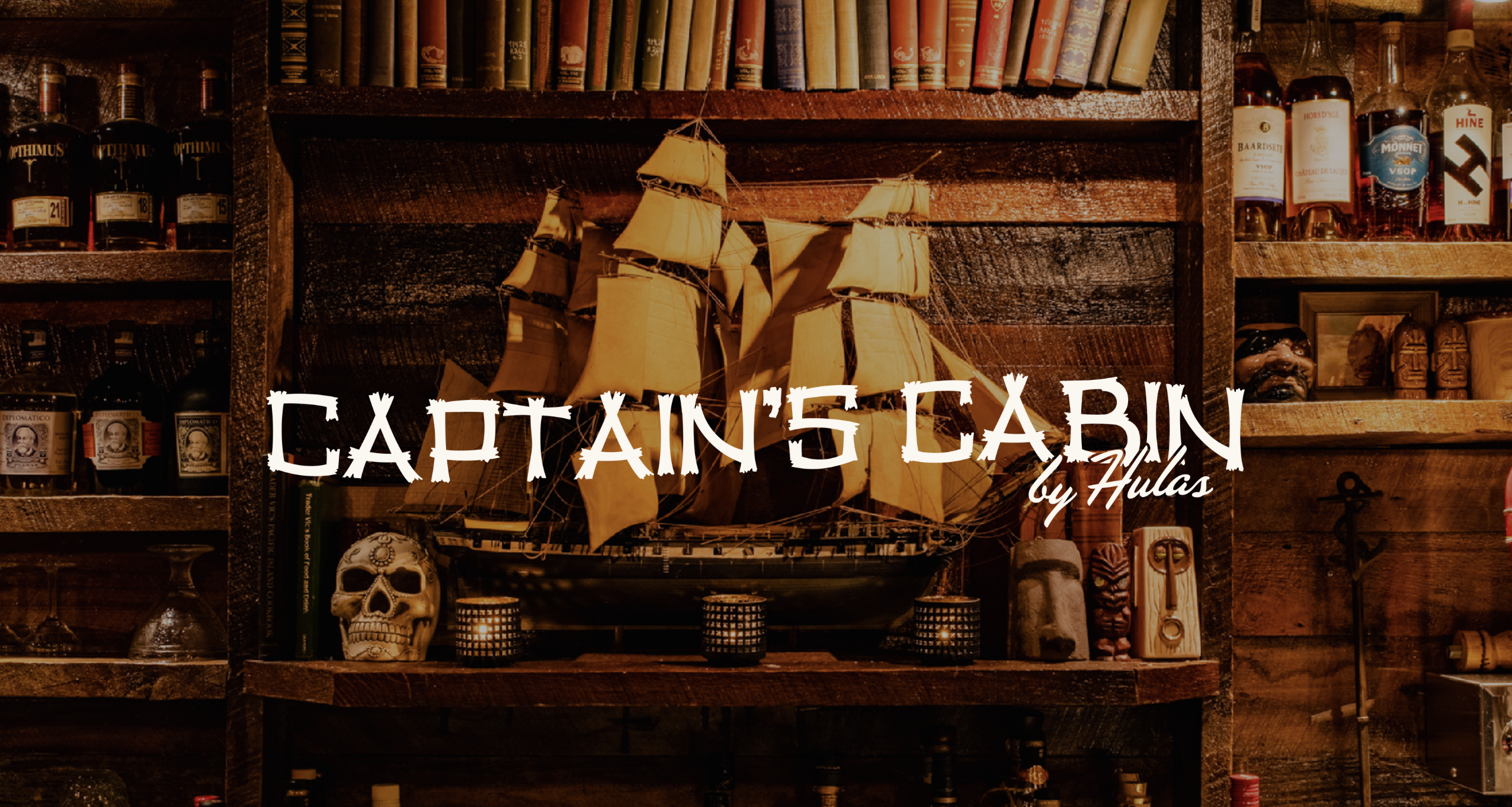 Model ship and skull on a wooden shelf with bottles and books.