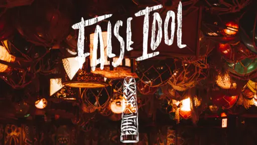 Dimly lit bar with warm colored lights and "False Idol" sign.
