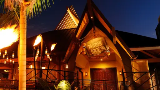 Tropical-style restaurant entrance at night, lit by torches.