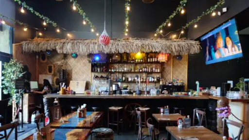 Tropical-themed bar with hanging lights and tiki decor.