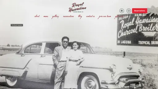 Black and white photo of a couple leaning on a vintage car next to a roadside billboard.